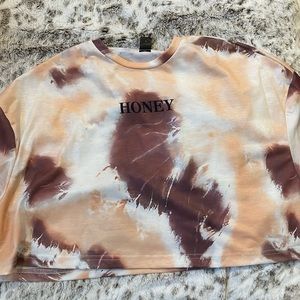 A tie dye multicolored shirt that says HONEY